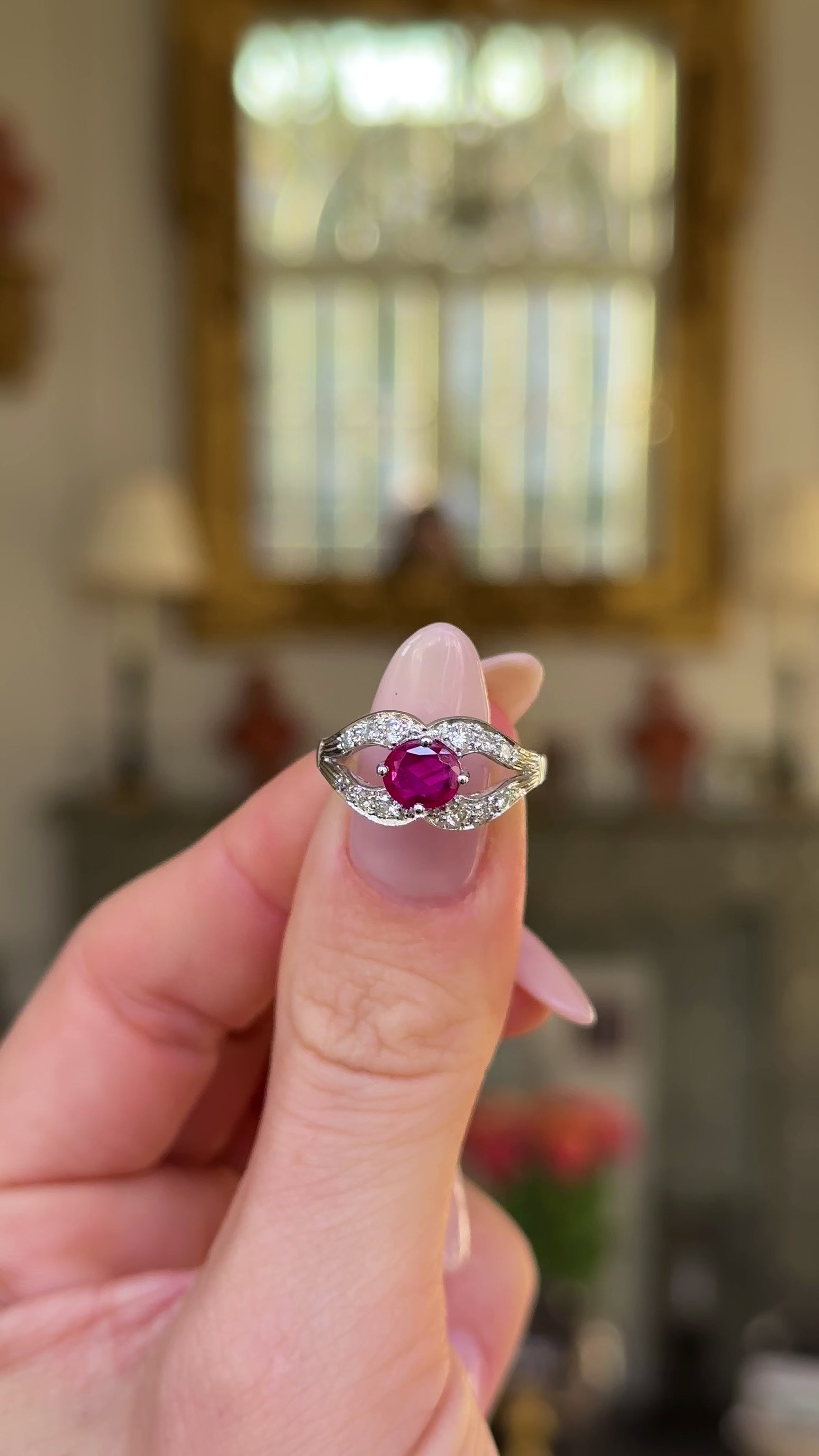 Vintage art deco ruby and diamond ring held in fingers and moved around to give perspective.