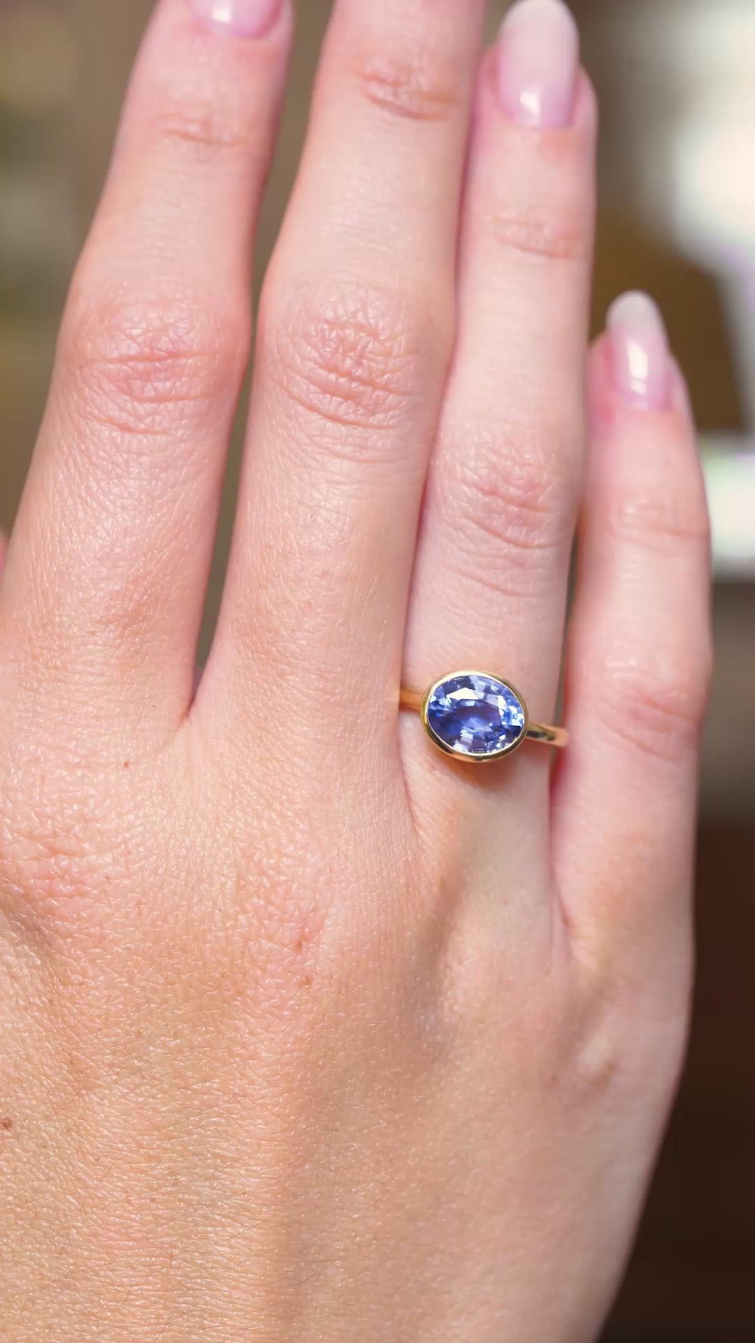 A video of an antique-inspired blue sapphire solitaire engagement ring in yellow gold worn on the hand.