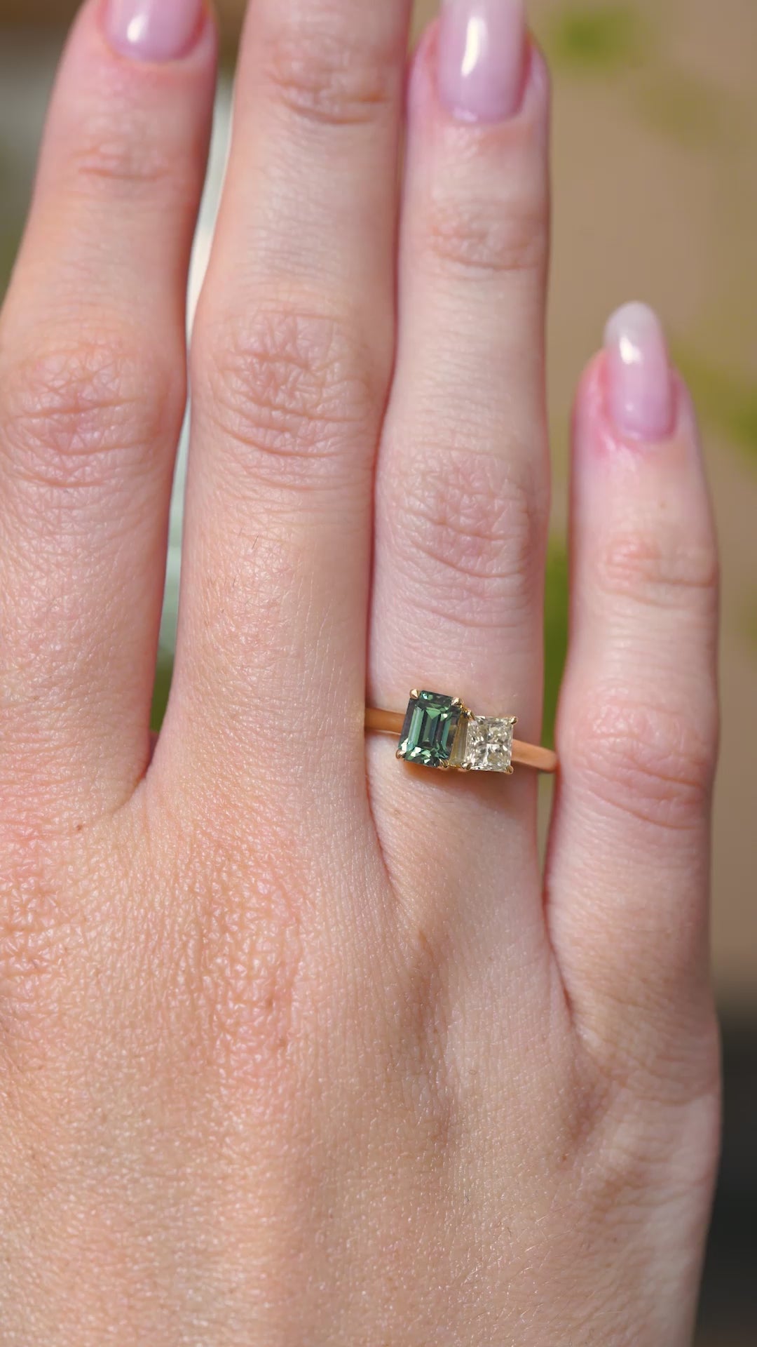Video of green sapphire and diamond toi et moi worn on the hand.