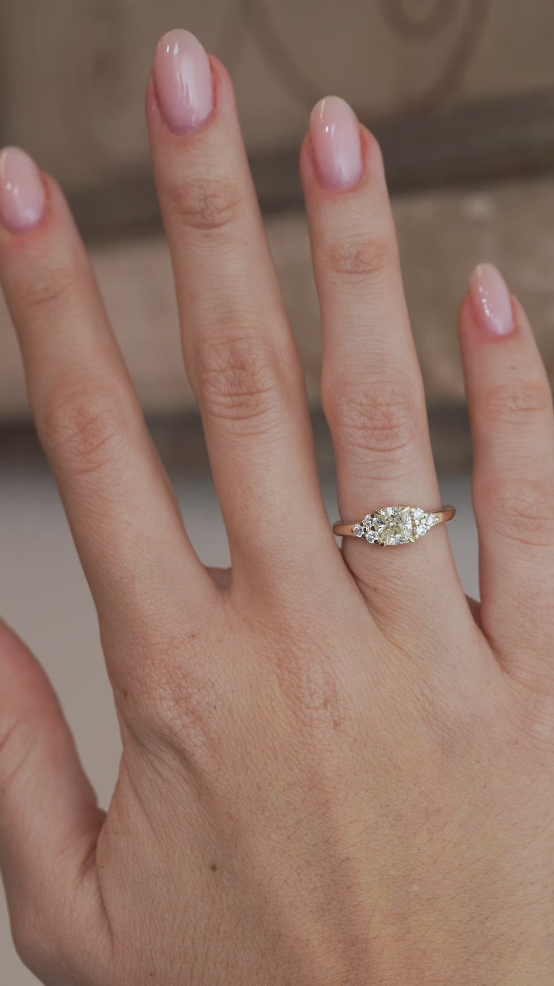 A video of the diamond trefoil engagement ring worn on a finger, capturing the sparkle of the central diamond and surrounding stones.