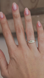 A video of the diamond trefoil engagement ring worn on a finger, capturing the sparkle of the central diamond and surrounding stones.