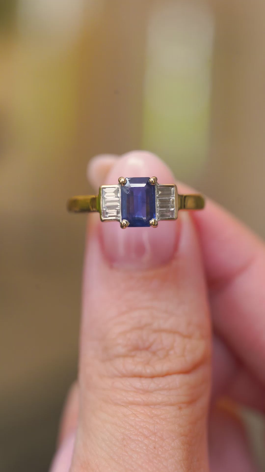 A video of the front view of a rectangular sapphire flanked by two baguette-cut diamonds.