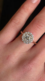 Diamond cluster yellow gold engagement ring on hand in video showing brilliance and scale. 
