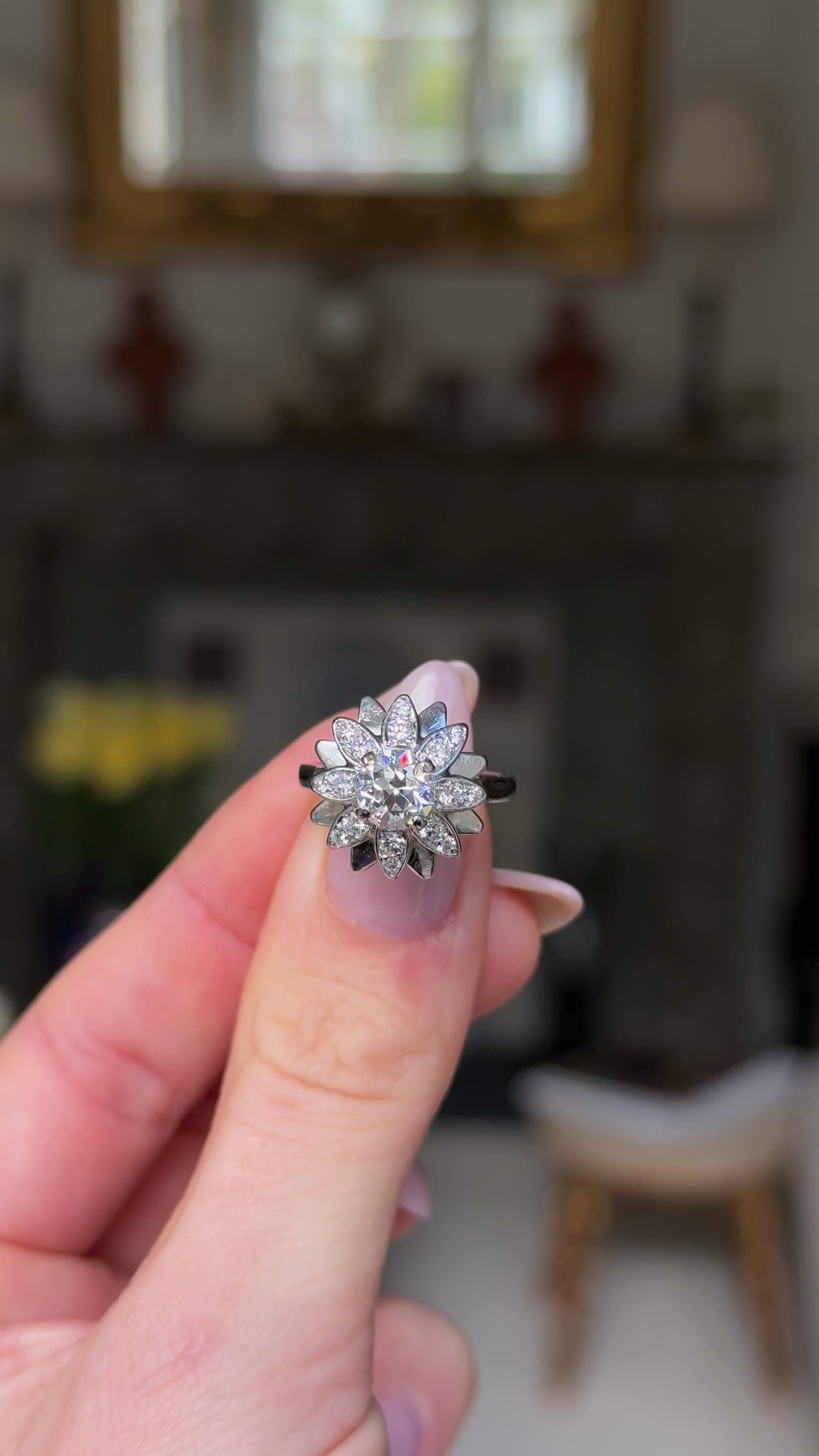 french diamond engagement ring resembling a flower held in hand and rotated to give perspective. 