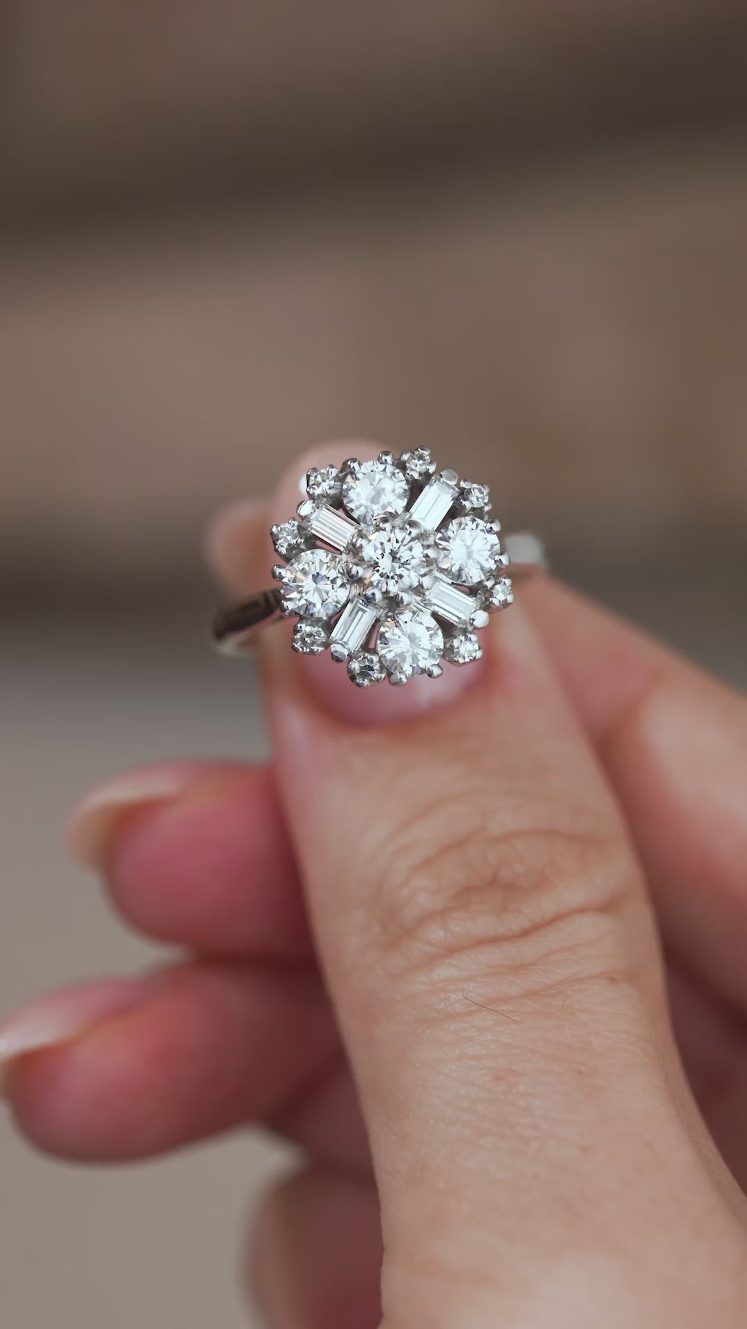 A close-up video of the 1980s diamond cluster ring held between fingers, showcasing its sparkling diamonds and distinctive geometric design.