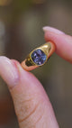 A close-up video of an antique Victorian colour-change sapphire gypsy ring held between the fingers showcasing various angles of the ring.