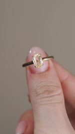 A video showing the sapphire solitaire held between fingers, revealing the pale golden hues and natural facets of the centre stone.