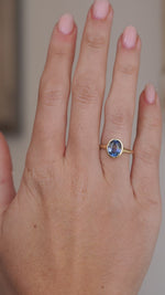 Video showcasing the oval sapphire ring on the hand from a wider perspective, with the yellow gold setting framing the gemstone.