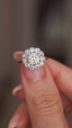 A video of an Antique, Edwardian diamond cluster engagement ring in platinum held between the fingers and slowly rotated to show off different angles.