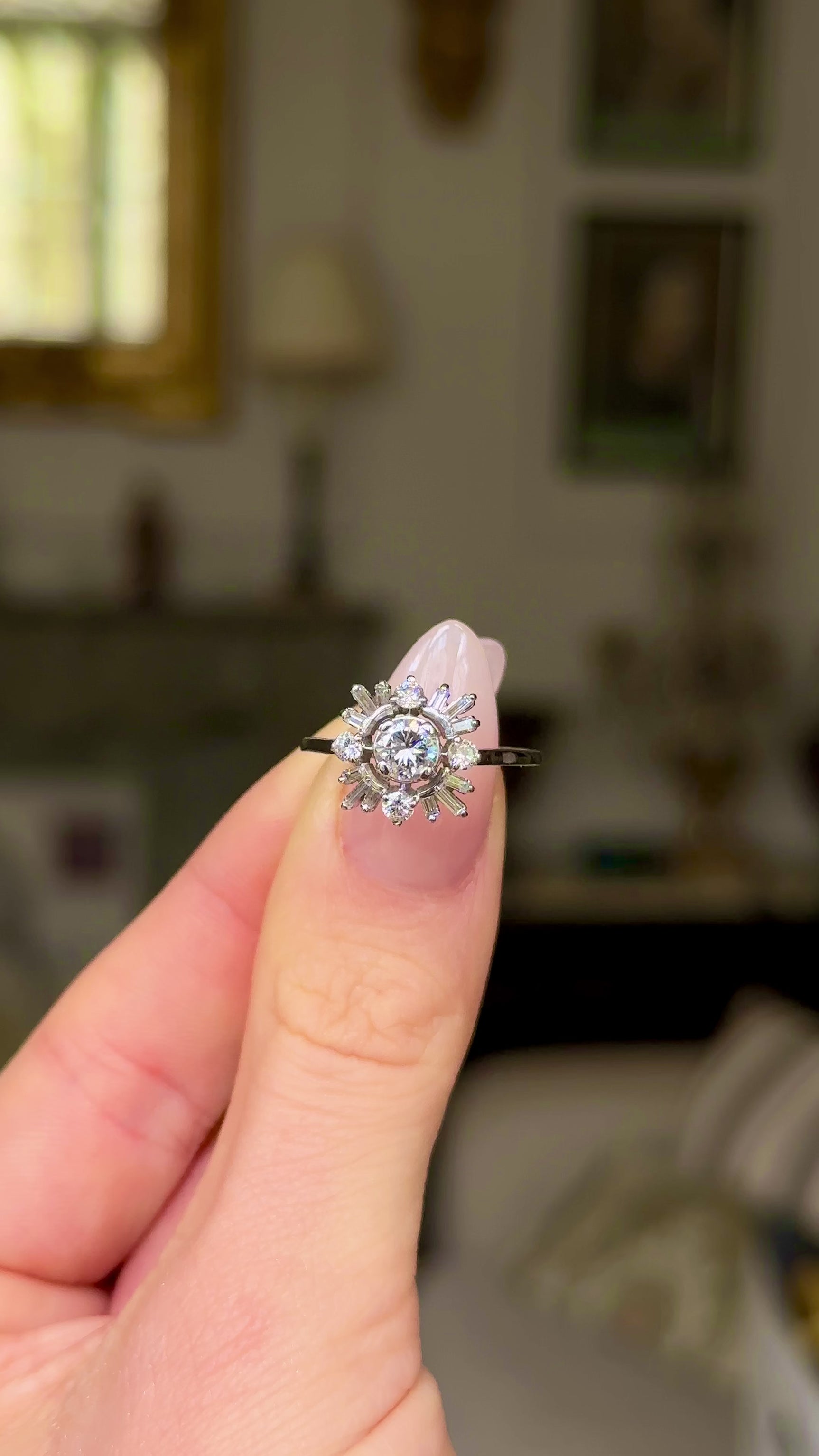 Vintage diamond cluster ring, held in fingers and moved around to give perspective.