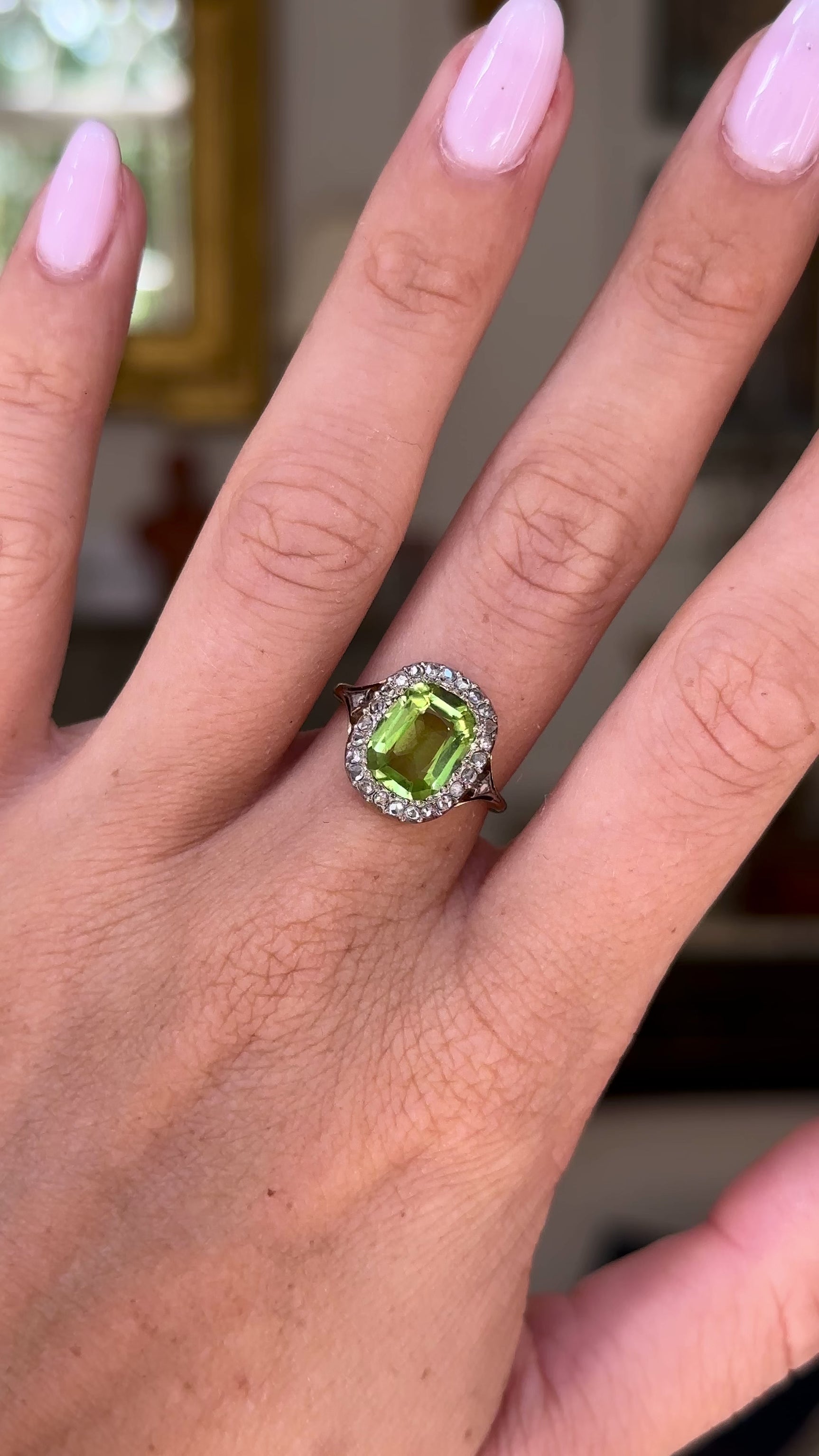 antique peridot and diamond ring, worn on hand and moved away from lens to give perspective, front view.