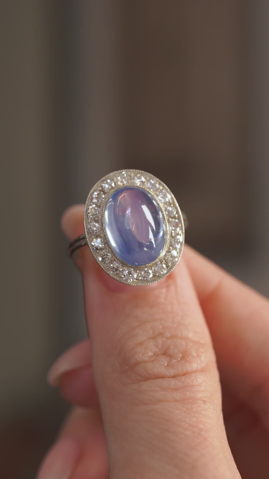 Video presenting the sapphire and diamond ring balanced on a fingertip for a detailed face-on view of the Victorian cluster.