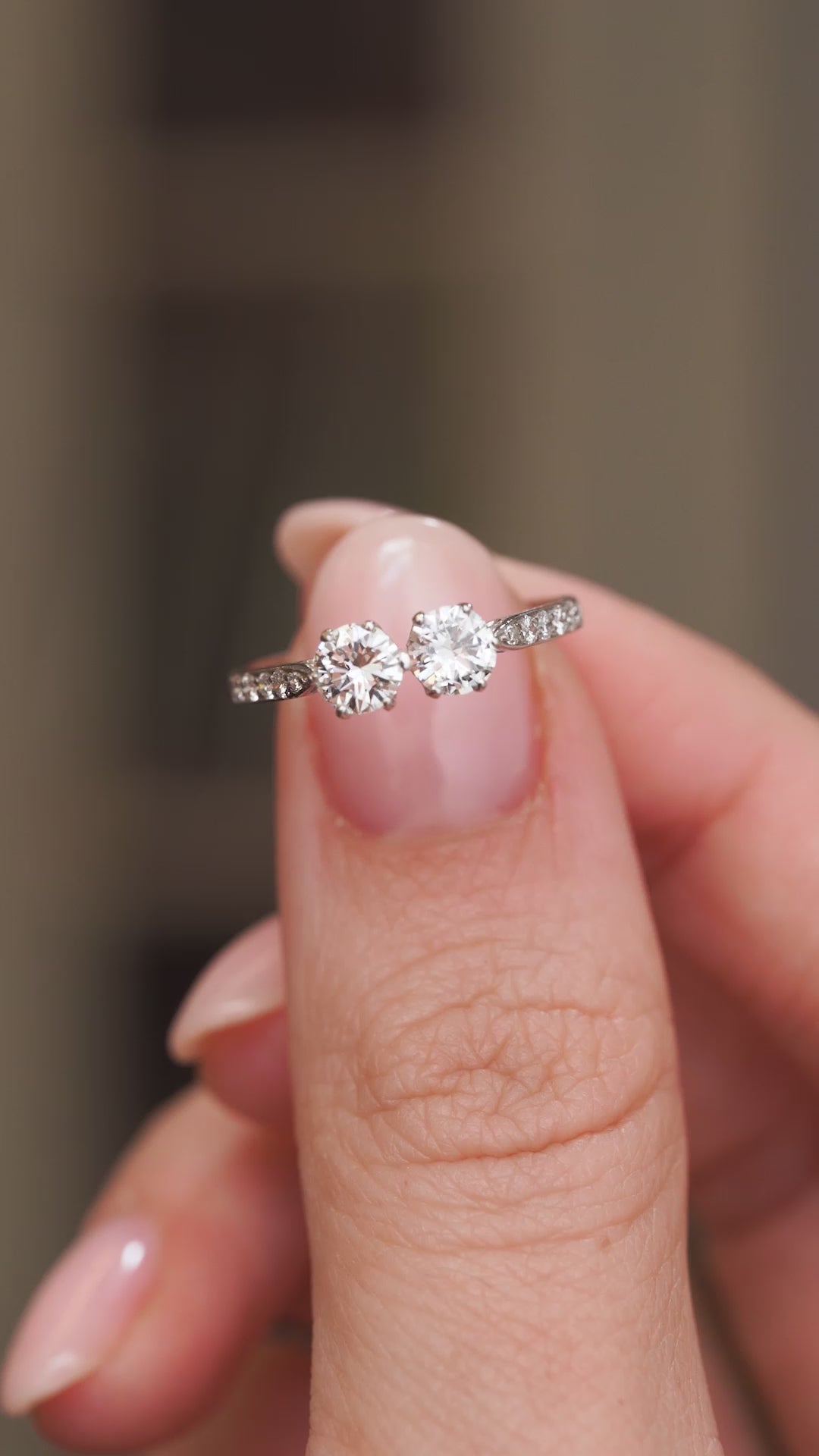 Video presenting the antique diamond toi et moi engagement ring balanced on a fingertip for a clear face-on view.