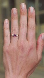 Ruby and diamond three stone ring worn on hand showing deep red tone and natural movement.