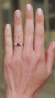 Ruby and diamond three stone ring worn on hand showing deep red tone and natural movement.
