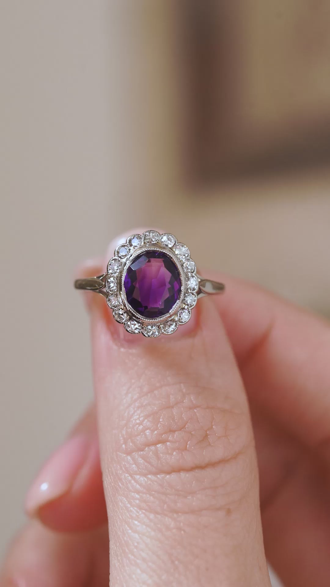 Video detail of the Edwardian amethyst ring balanced on a fingertip, highlighting the scalloped old-cut diamond cluster.