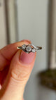 Antique, Edwardian three-stone diamond twist ring held in fingers.