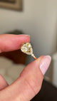 Video of a Vintage-inspired yellow gold engagement ring, set with a pale yellow cushion-cut sapphire flanked by diamonds.  Held between two fingers and rotated slowly to showcase the stones.