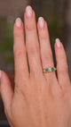 A video of an outstretched hand wearing an Antique, Victorian emerald and diamond five-stone engagement ring in yellow gold. 