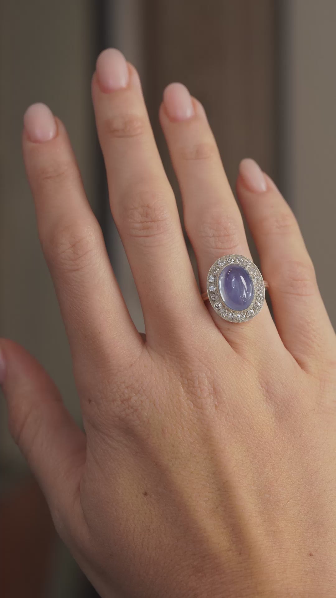 Video showcasing the Victorian cabochon sapphire ring on the hand as light moves across its smooth blue surface and diamond surround.