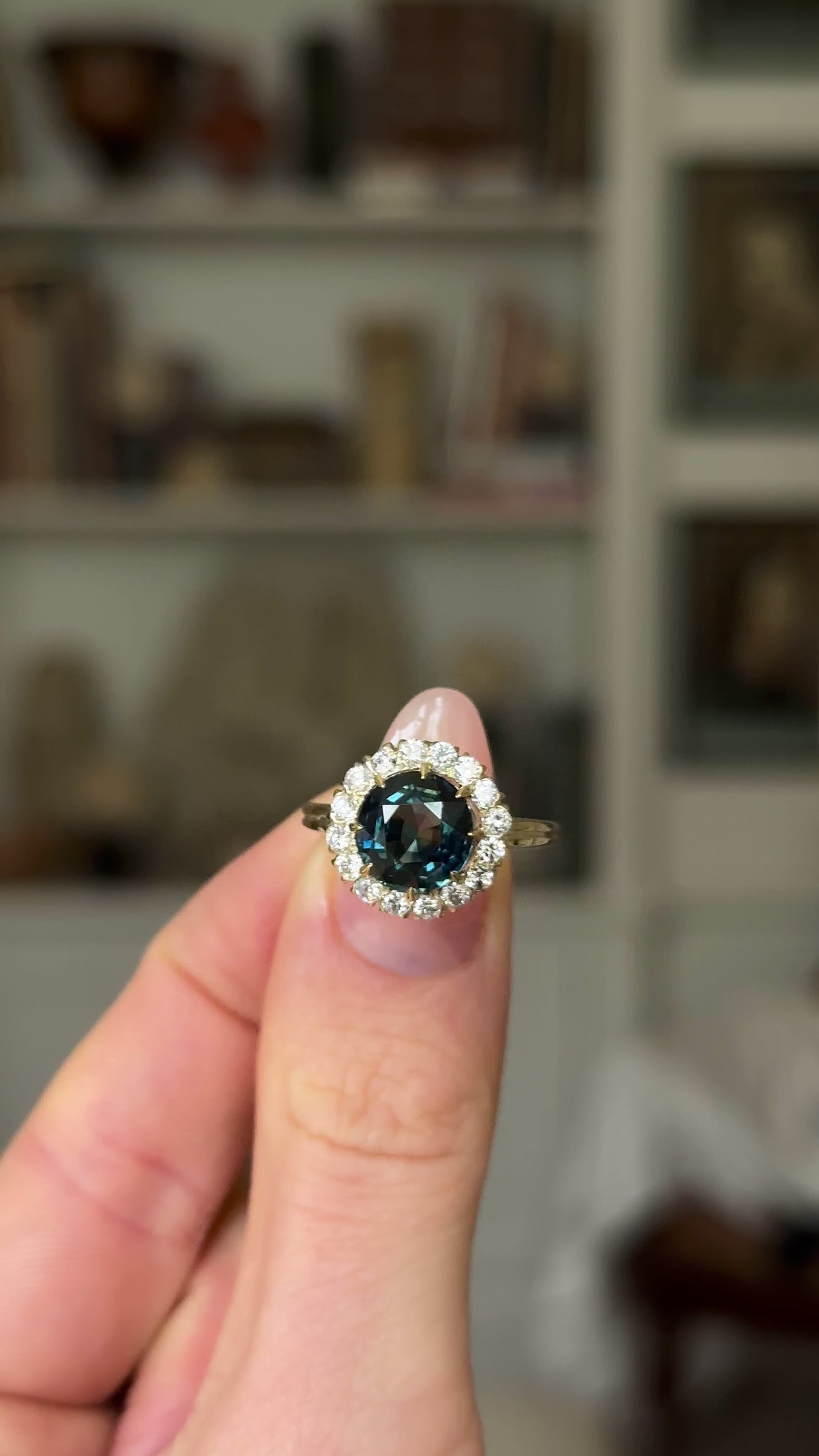 Antique, Teal Blue Sapphire and Diamond Cluster Ring, 18ct Yellow Gold held in fingers and rotated to give perspective.