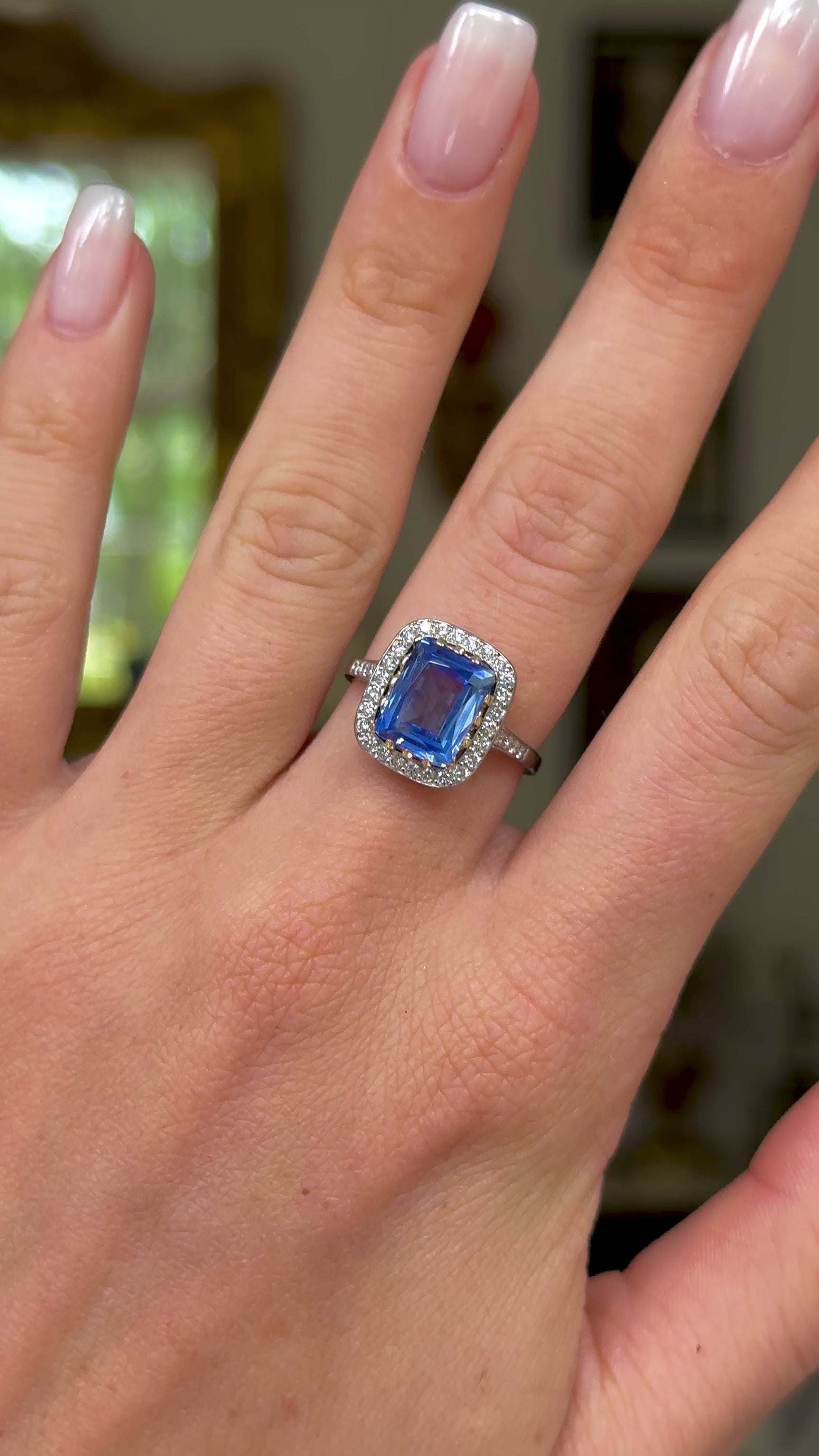 vintage sapphire and diamond cluster engagement ring worn on hand and moved around to give perspective.