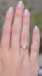 A video of a hand moving whilst wearing an Antique, Edwardian diamond daisy cluster engagement ring in yellow gold.