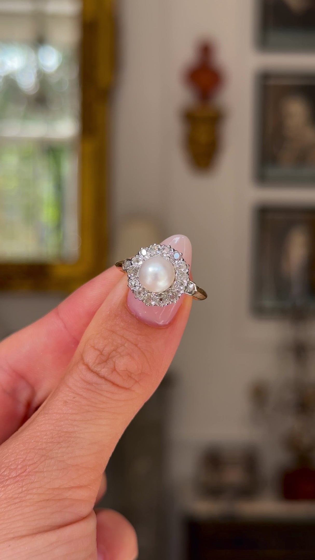 Antique pearl and diamond cluster ring held in fingers and moved around to give perspective.