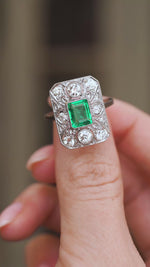 Video close-up of the Art Deco cluster ring balanced on a fingertip, highlighting its intricate platinum lacework.