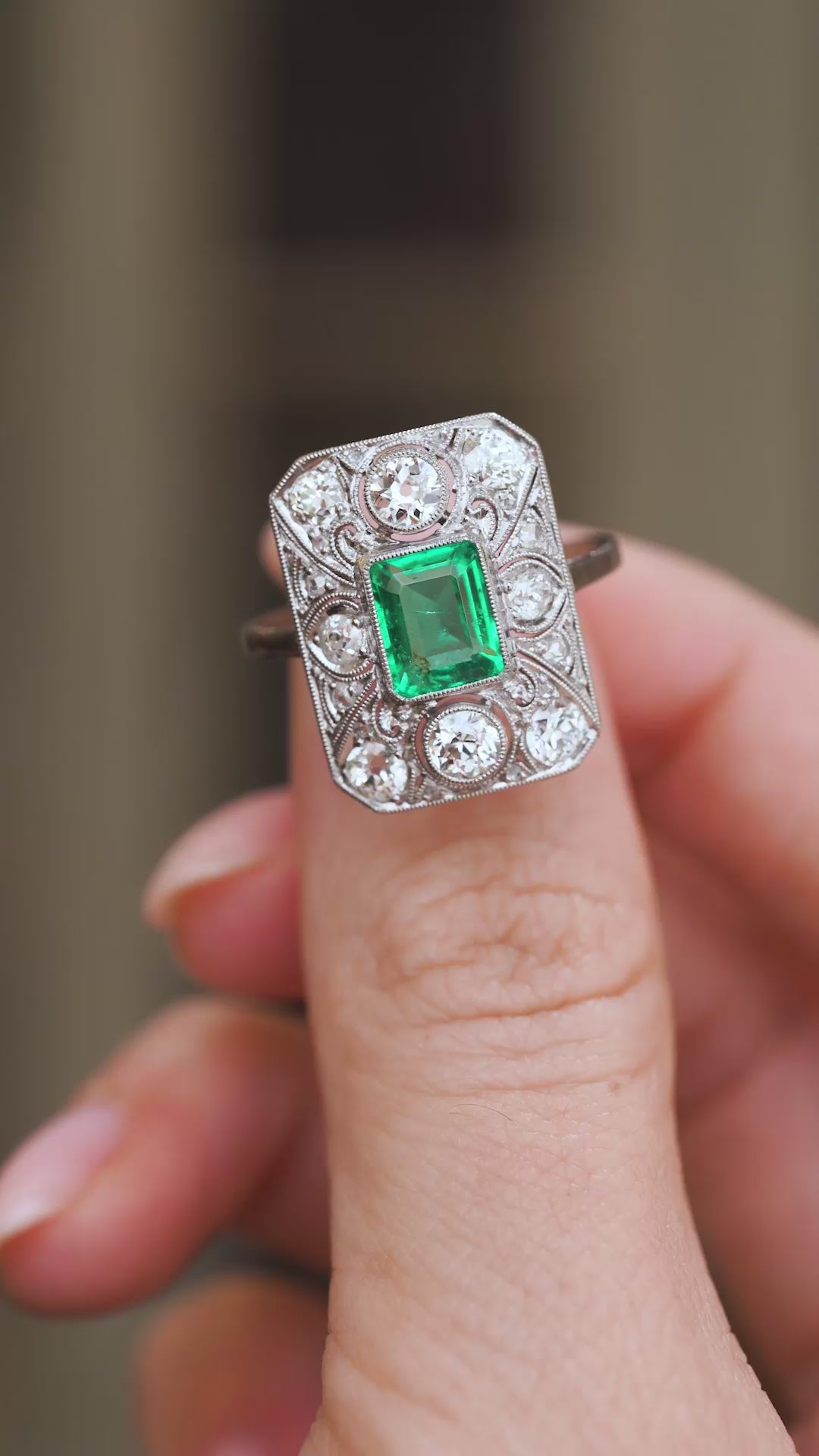 Video close-up of the Art Deco cluster ring balanced on a fingertip, highlighting its intricate platinum lacework.