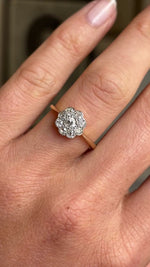 Close up video of an Antique Edwardian daisy cluster diamond ring in yellow gold worn on a wedding finger. 
