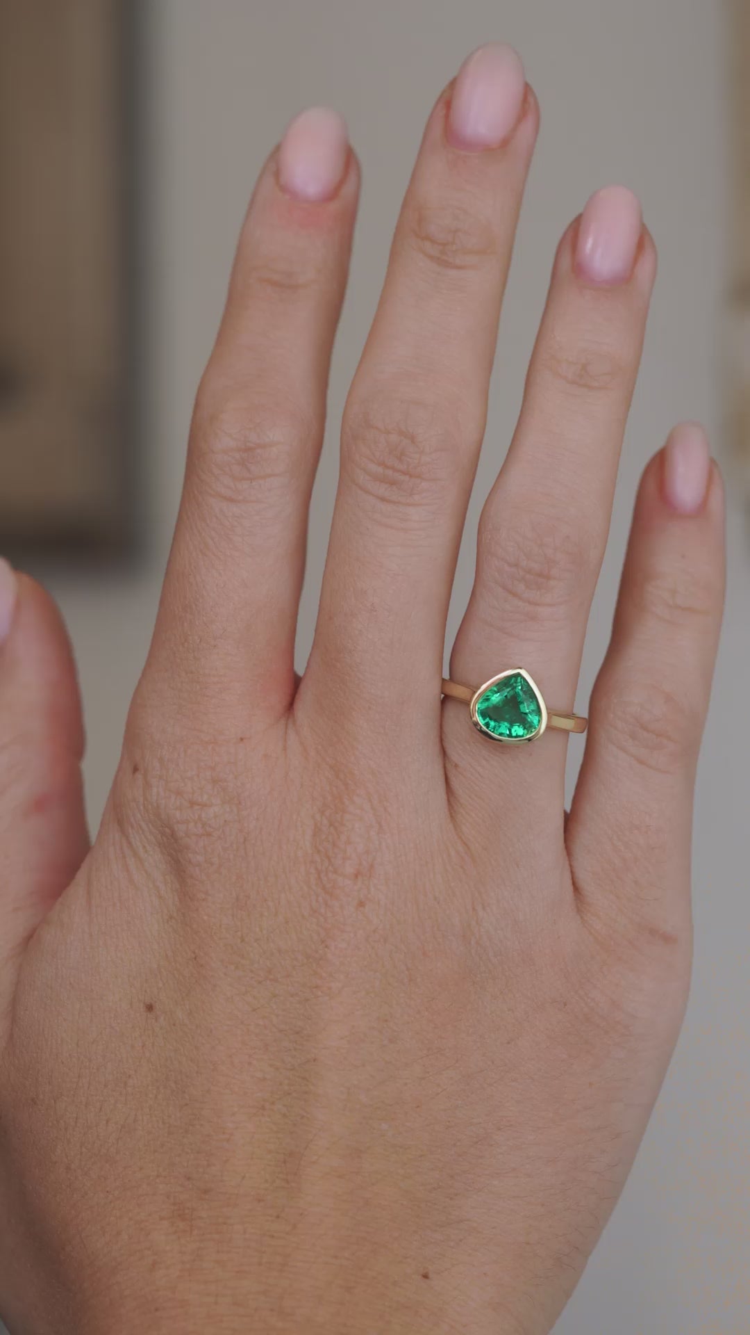 Video showcasing the emerald engagement ring on the hand as light moves across the pear-cut stone.