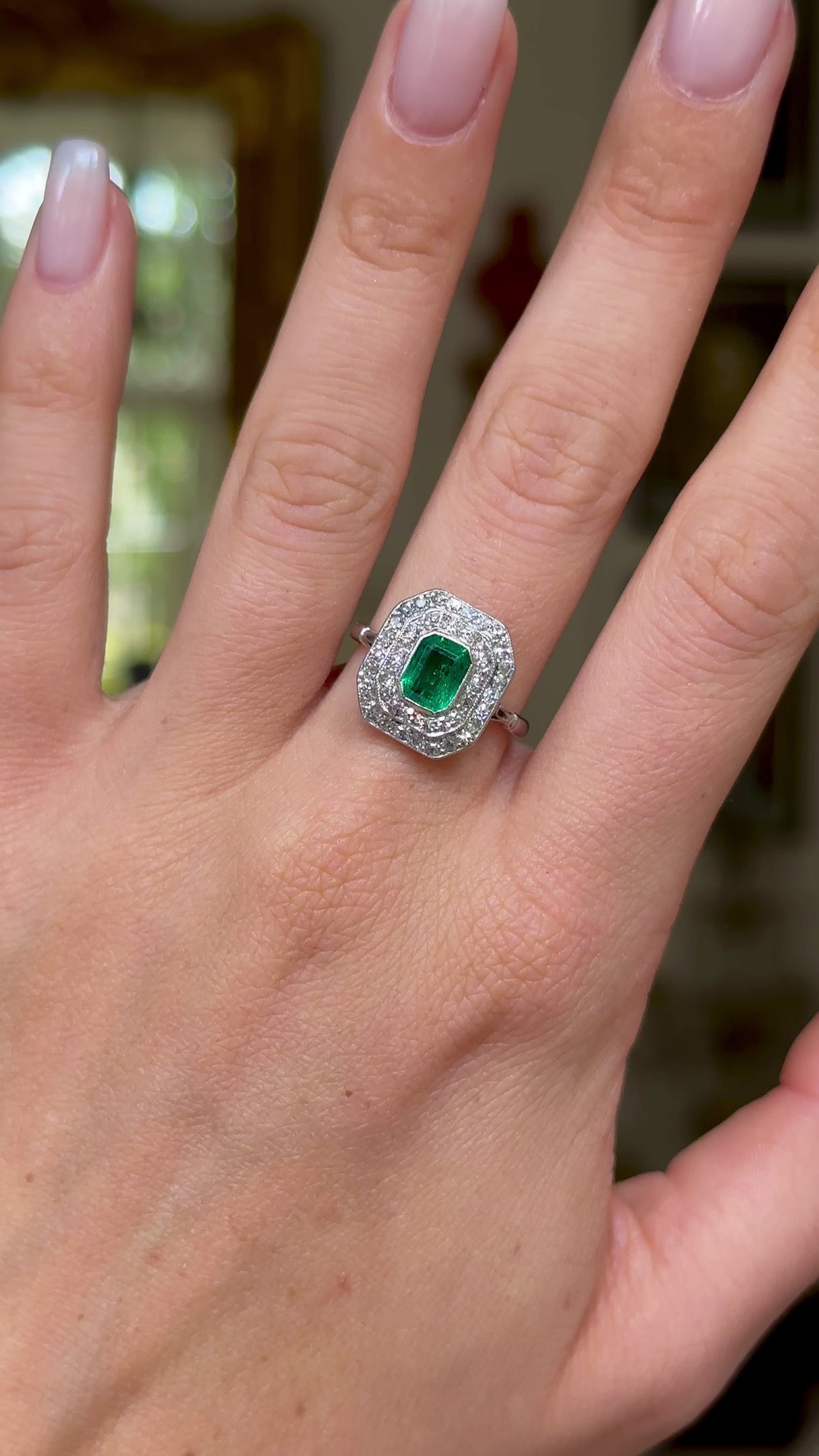 Vintage emerald and diamond cluster ring, worn on hand and moved around to give perspective.
