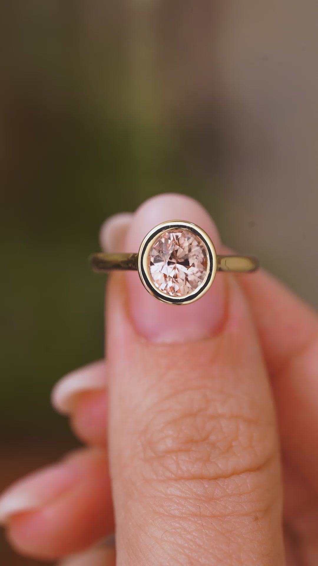A close up video of an Antique-inspired,  sapphire solitaire engagement ring, rotated slowly to showcase the pinkish-brown colour of the Sri Lankan sapphire and the yellow gold setting and band.