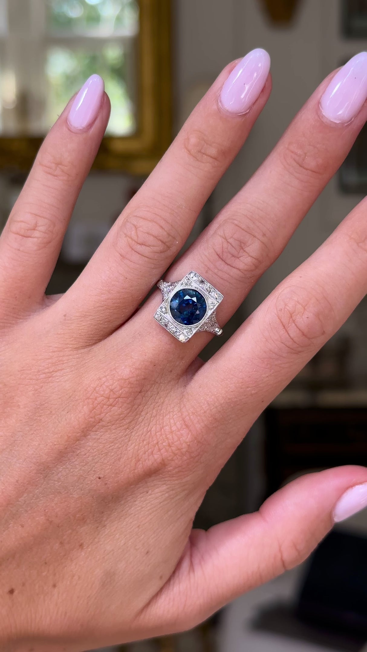 sapphire and diamond panel ring worn on hand moving around to give perspective.