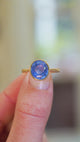 Blue sapphire ring showing light reflections and gold setting detail.