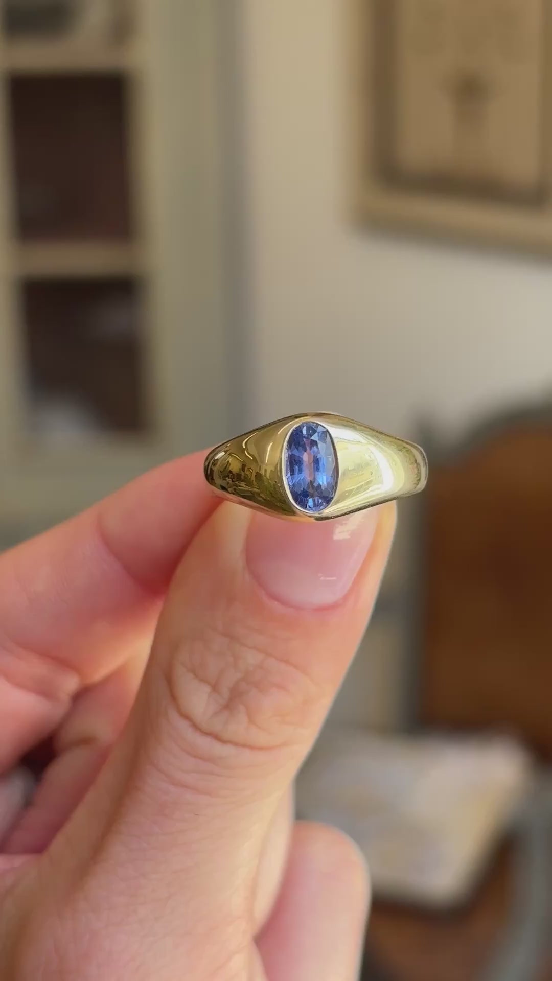 Antique Edwardian iris-blue sapphire gypsy engagement ring showcasing an iris-blue sapphire in a classic gold gypsy setting, held by hand to highlight the craftsmanship and design.