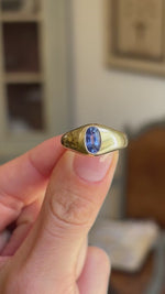 Antique Edwardian iris-blue sapphire gypsy engagement ring showcasing an iris-blue sapphire in a classic gold gypsy setting, held by hand to highlight the craftsmanship and design.