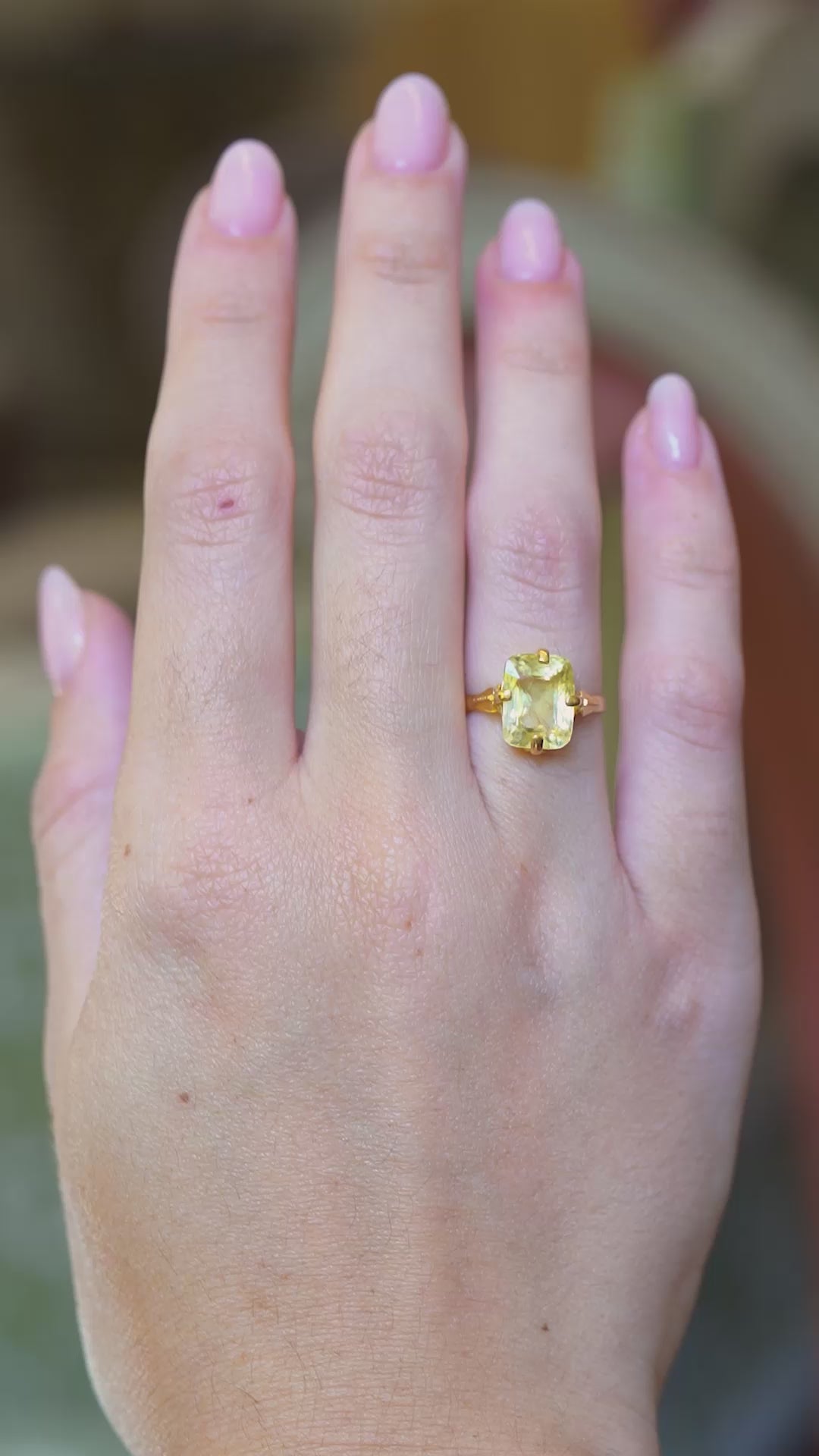 Antique Victorian yellow sapphire solitaire ring worn on hand with subtle motion.