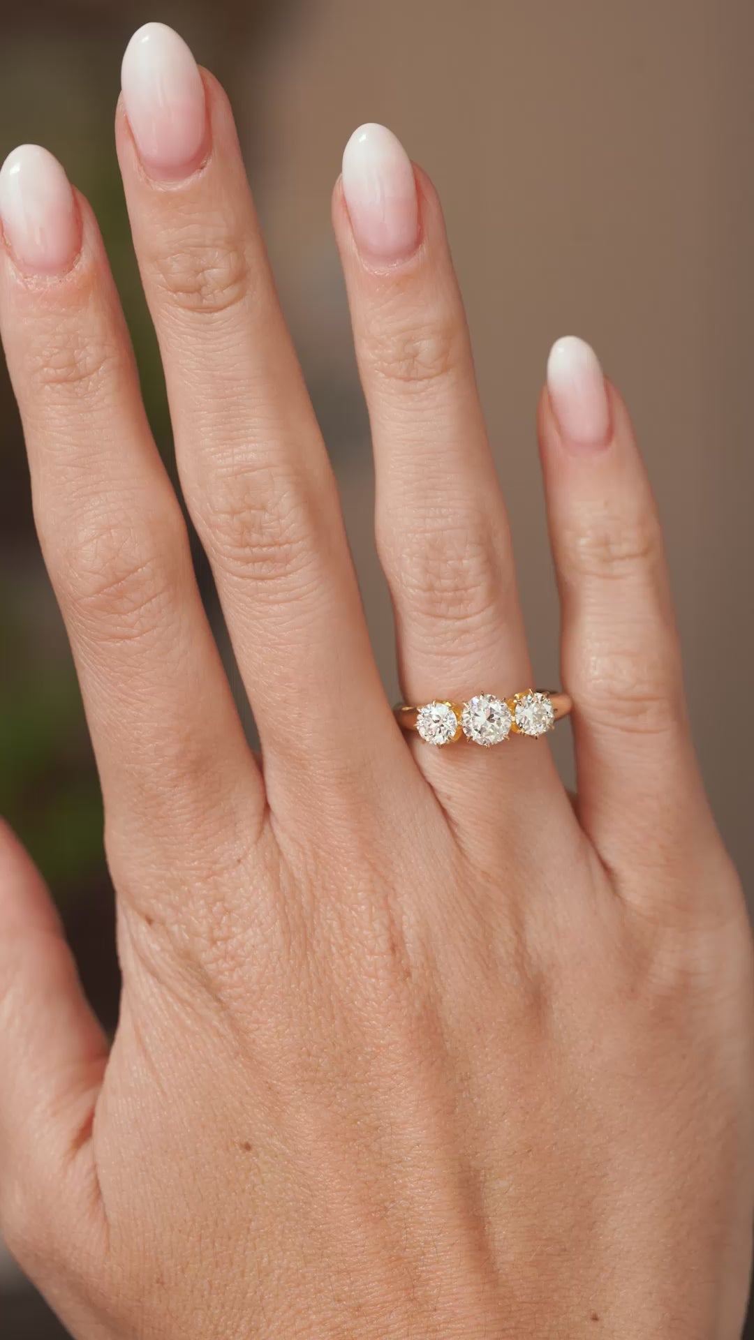 Video of a vintage diamond three-stone engagement ring worn on the hand, highlighting the sparkle and proportions of its antique-cut diamonds.