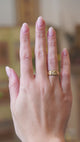 Antique Edwardian three-stone diamond gypsy ring worn on hand in motion.