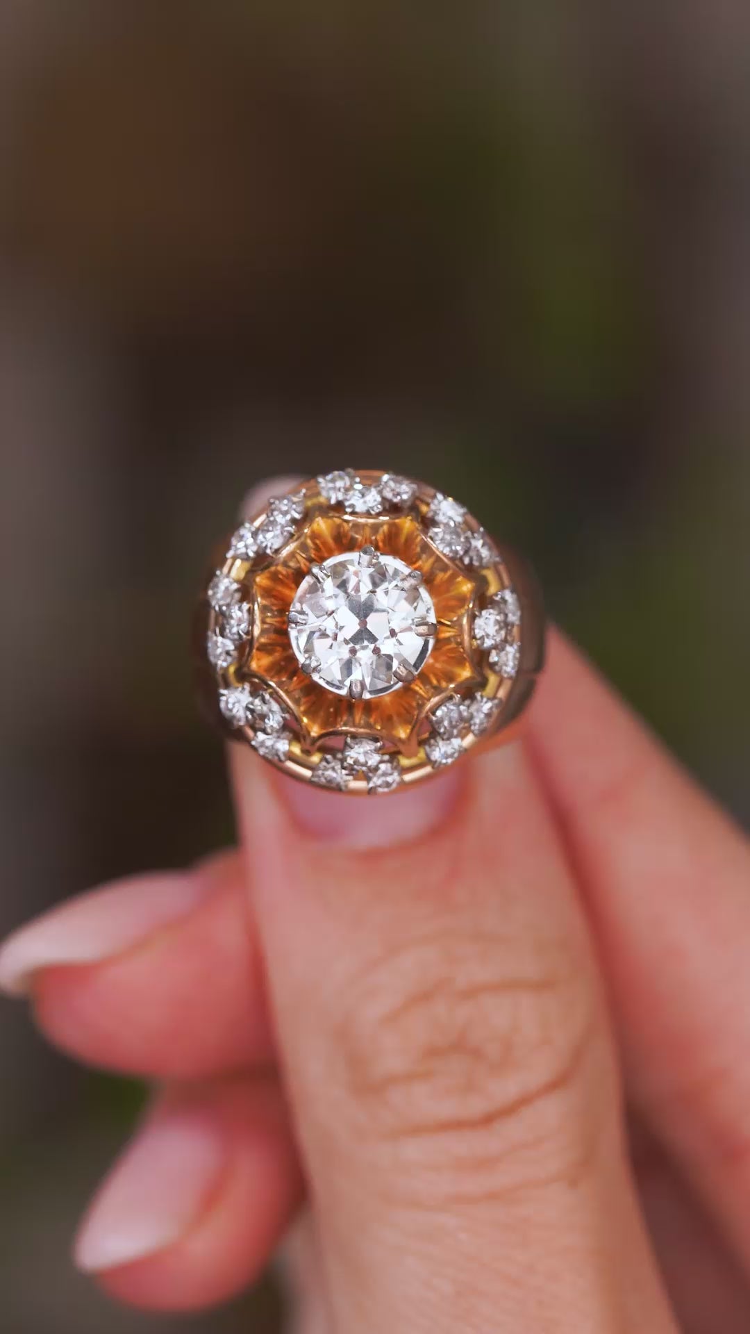 A close up video of a Vintage, 1960s French old cut diamond cocktail cluster ring rotated slowly to show the intricate gold work and yellow gold band.
