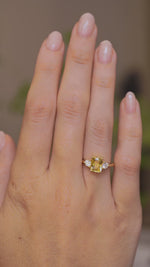 A video of an Antique-inspired, Yellow sapphire and diamond three-stone engagement ring worn on the hand as it slowly turns