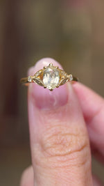 A detailed video view of a vintage-inspired yellow gold engagement ring featuring an oval-cut yellow sapphire with diamond accents.