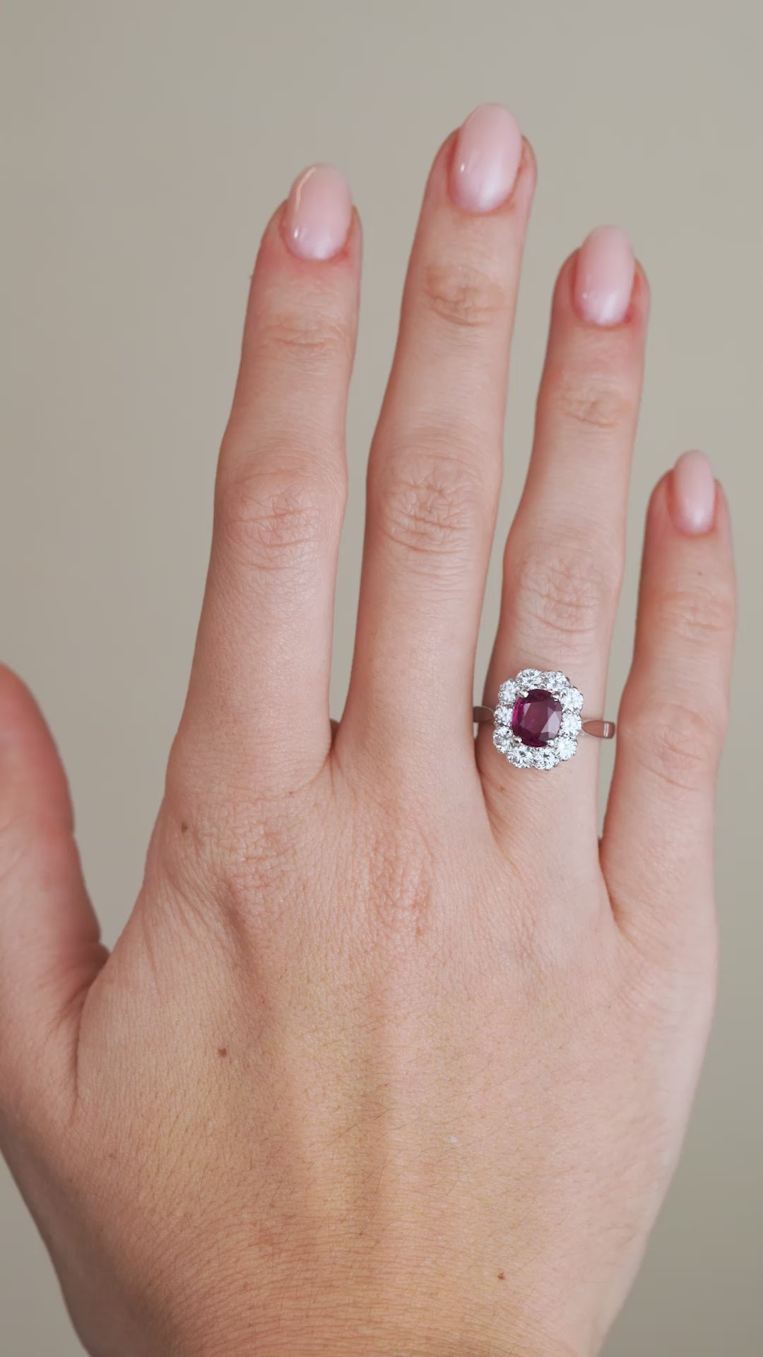 A video of the vintage ruby and diamond ring on a finger, capturing the gemstone's vivid colour and the brilliance of its diamond halo.