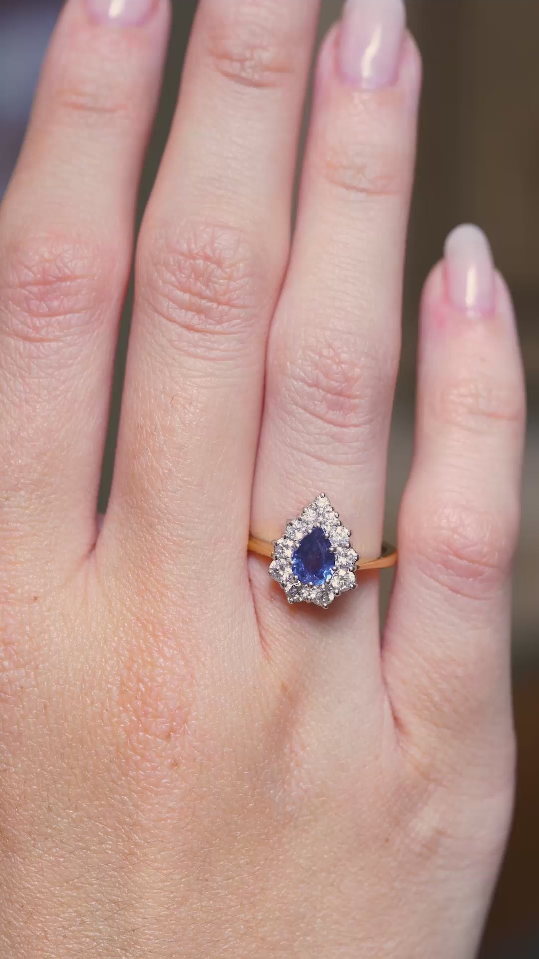 a video of a Vintage sapphire and diamond cluster engagement ring worn on the hand