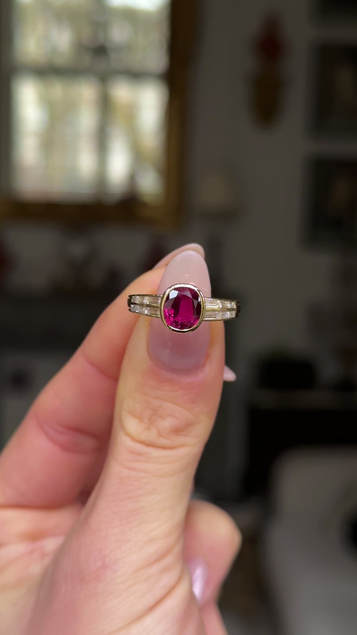 Art Deco ruby and diamond ring held in fingers and moved around to give perspective.