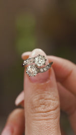 A video of fingers holding Antique, Edwardian diamond toi et moi engagement ring and turning to show different angles.