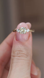 A close-up video of the three-stone diamond ring held between fingers, showcasing the diamonds' brilliance and sparkle.