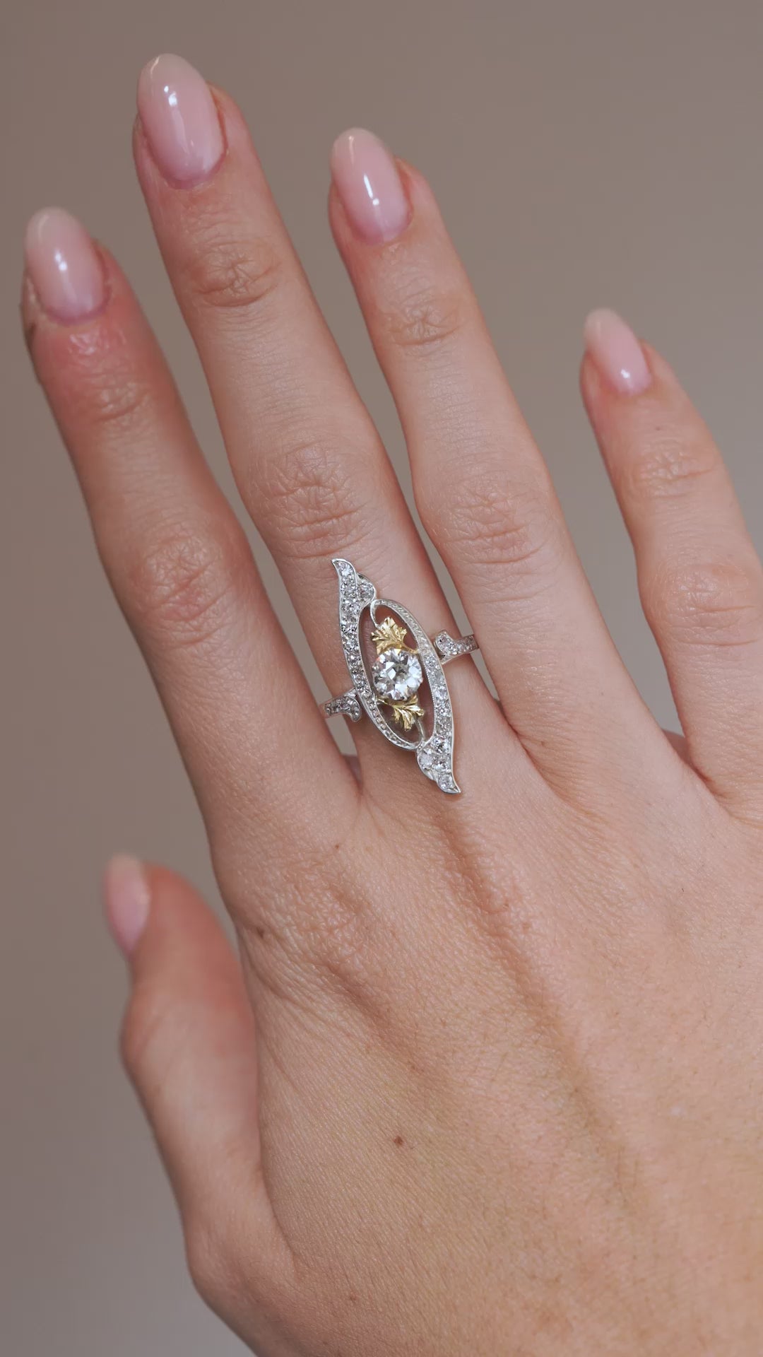 Video: Antique Art Nouveau diamond cross-over ring modelled on the hand, highlighting its distinctive shape and diamond sparkle.